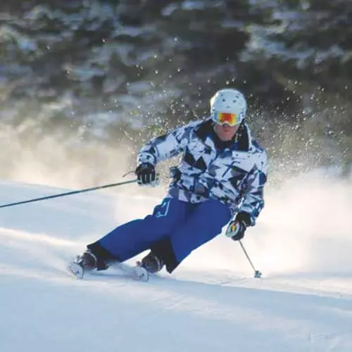 Michael Botti skiing and kicking up powder